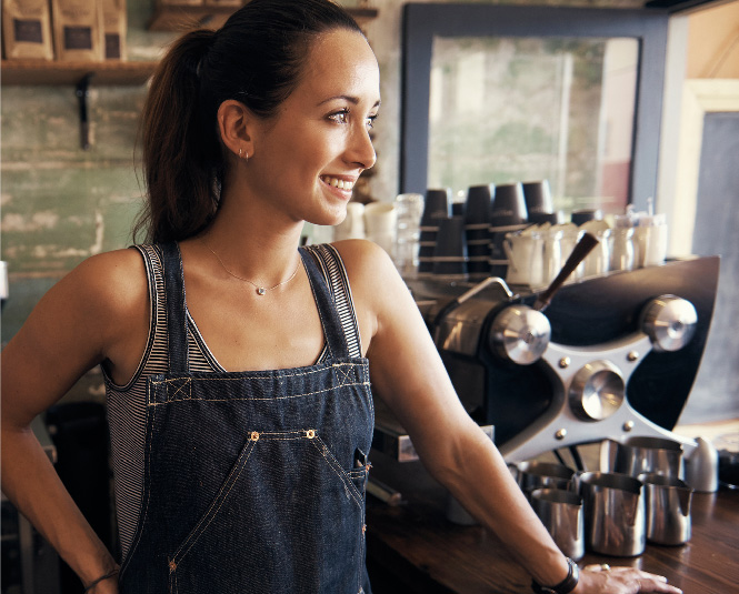 Young female business owner smiling in a coffee shop.