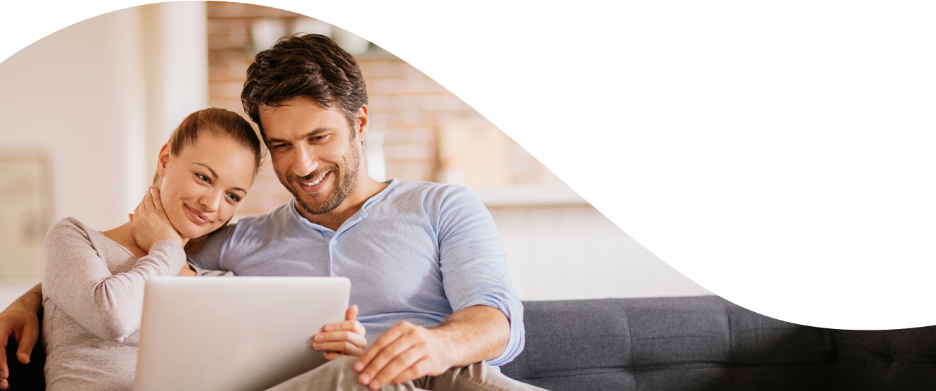Banner image of couple on sofa using computer
